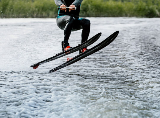 Man waterskiing on lake behind