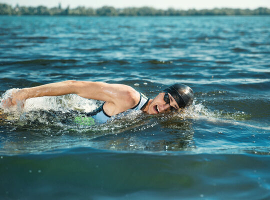 Professional triathlete swimming in river